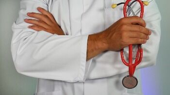 Physician with his arms crossed, holding a stethoscope